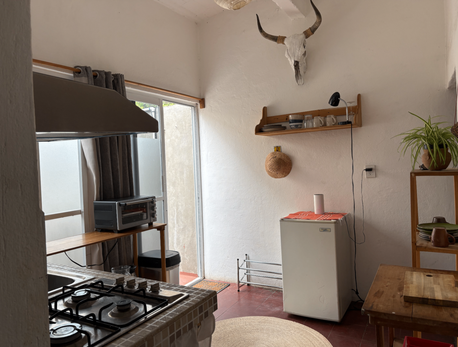 Private kitchen with refrigerator, stove, and warm wood accents.